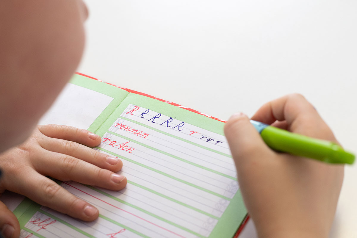 student writing in cursive work book